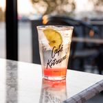 Chilled fruit drink with lemon slice on a marble table at Café Kitsuné.